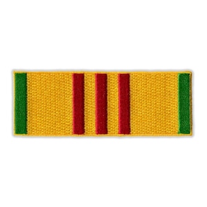 May include: Embroidered rectangular patch with a yellow background, three vertical red stripes, and green borders on each end. The patch is likely a military or service ribbon.