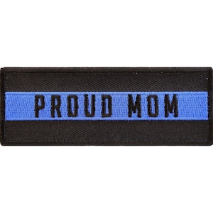 May include: Black and blue embroidered patch with the text "PROUD MOM" on a black background.