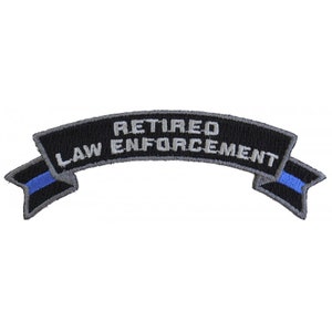 May include: Black and silver embroidered patch with a blue line. The patch reads "Retired Law Enforcement" on a curved banner.