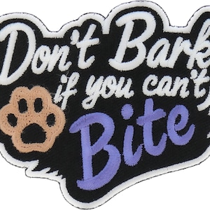 May include: Black and white embroidered patch with the text "Don't Bark if you can't Bite" in white lettering. A brown paw print is in the center of the patch.