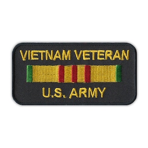 May include: A black embroidered patch with gold lettering that reads "Vietnam Veteran" and "U.S. Army". A yellow ribbon with red and green stripes is centered above the text.
