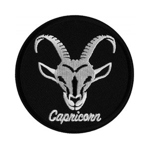 May include: White embroidered Capricorn zodiac sign on a black circular patch. The patch has a white embroidered border.