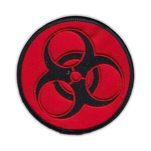 May include: A red and black embroidered patch with a biohazard symbol. The symbol is a black triangle with three circles inside.