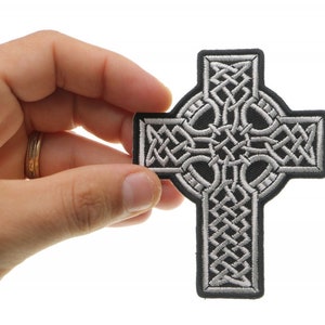 May include: A silver Celtic cross embroidered patch with a black background. The cross is a traditional Irish symbol of faith and heritage.