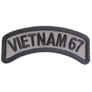 May include: A gray embroidered patch with black stitching that reads "VIETNAM 67".