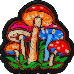 May include: Embroidered patch featuring a cluster of colorful mushrooms. The mushrooms have red, orange, blue, and pink caps with white spots and tan stems. Green leaves are at the base, all outlined in black.