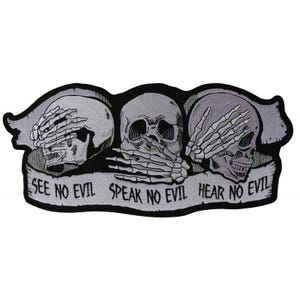 May include: Black and white embroidered patch with three skulls, each covering their eyes, mouth, or ears. The skulls are arranged in a row with a banner below that reads "See No Evil Speak No Evil Hear No Evil".