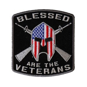 May include: Black and gray embroidered patch with a Spartan helmet design. The helmet is overlaid with an American flag. The text "BLESSED ARE THE VETERANS" is embroidered in gray.