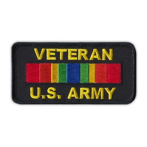May include: Black embroidered patch with yellow text that reads "Veteran U.S. Army". A rainbow ribbon is above the text.