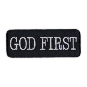 May include: Black embroidered patch with white text that reads "GOD FIRST".