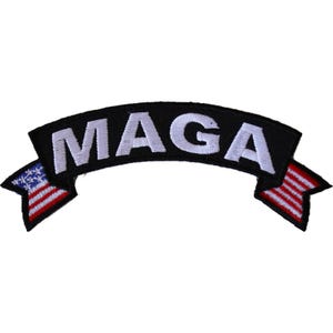 May include: A black patch with the word "MAGA" in white block letters. The patch has a curved banner shape with American flag designs on each end, featuring red and white stripes and blue stars.