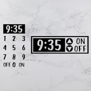 以下が含まれることがあります： 9:35 を表示する黒と白のデジタルタイマー。タイマーには、「ON」と「OFF」のラベルが付いたボタンが2つあります。