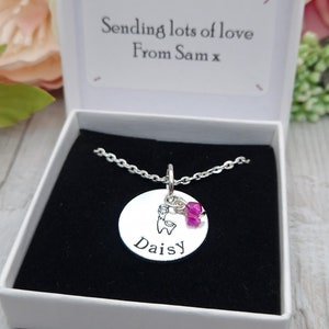 May include: A silver necklace with a round pendant that says "Daisy" and a small silver charm of a tooth. The necklace is in a white gift box with a message that says "Sending lots of love From Sam x".