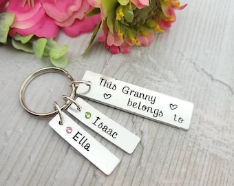 May include: Silver keychain with three tags. The top tag says "This Granny belongs to" with a heart symbol on each side of the text. The middle tag says "Isaac" and the bottom tag says "Ella".