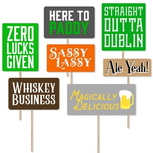 Puede incluir: Conjunto de diez accesorios para cabina de fotos en verde, naranja, marrón y gris con palos. Los letreros tienen frases como "Zero Lucks Given", "Here to Paddy", "Sassy Lassy", "Straight Outta Dublin", "Ale Yeah!" y "Whiskey Business".