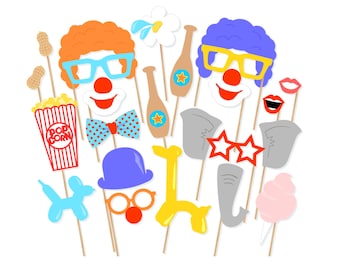 May include: A set of 12 colorful photo booth props with a circus theme. The props include a clown face, a popcorn box, a clown nose, a bow tie, a pair of glasses, a clown wig, a balloon animal, a cotton candy, a flower, a bottle, a pair of star-shaped glasses, and an elephant.