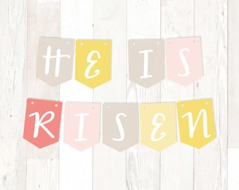 Könnte beinhalten: Ein Banner mit den Worten "He is Risen" in weißen Buchstaben auf verschiedenen farbigen Flaggen. Die Flaggen sind gelb, rosa, beige und rot.