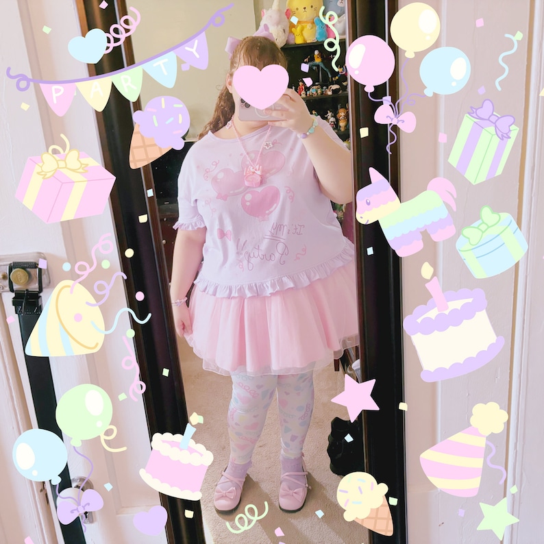 May include: A pink and white tulle skirt with a pink and white graphic tee shirt that says "You're My Favourite" with a pink heart and a pink bow. The person is wearing pink and white patterned tights and pink shoes.