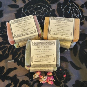 May include: Four bars of handmade soap with labels that read "Ancient Alchemy" and different scents. The scents are "Amas Veritas", "Tonight, I Fly!" and "Witches Black Soap".