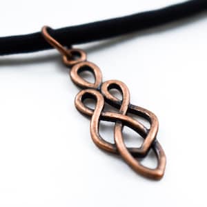 May include: A copper Celtic knot pendant necklace on a black cord.
