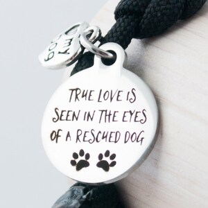 May include: Black paracord bracelet with a silver charm that reads "True love is seen in the eyes of a rescued dog" with two paw prints.