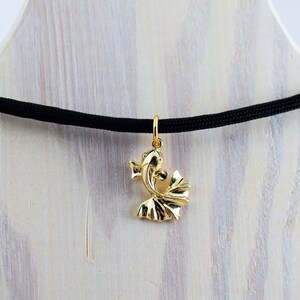 Puede incluir: Un collar con un colgante de pez dorado en un cord&oacute;n negro. El colgante es un dise&ntilde;o tridimensional detallado de un pez con sus aletas caudales extendidas.