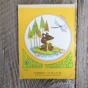 May include: A yellow and green illustration of a frog sitting on a lily pad with a dragonfly flying above. The illustration is surrounded by a circle with the text "Little Whimsy's" in green and white. The text "36 Sheets - 5 1/2 in. x 7 3/4 in." is below the circle. The text "Stuart Hall Co., Inc., Kansas City, Missouri 64108" is below the sheet count.