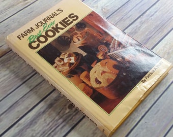 Könnte beinhalten: Ein gelbes Kochbuch mit dem Titel "Farm Journal's Best Ever Cookies" von Patricia A. Ward. Das Cover zeigt ein Foto einer Auswahl an Keksen in einer rustikalen Umgebung.