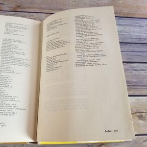 Pode incluir: Um close-up de um livro aberto com uma p&aacute;gina amarela mostrando o &iacute;ndice do livro. O &iacute;ndice lista v&aacute;rios tipos de biscoitos, incluindo manteiga de baunilha, bolachas de mel de trigo integral e biscoitos de mel selvagem e gengibre.