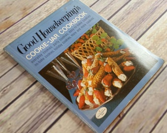 Könnte beinhalten: Ein blaues Kochbuch mit dem Titel "Good Housekeeping's Cookie-Jar Cookbook" mit einem Bild eines Tellers mit Keksen und Erdbeeren auf dem Umschlag.