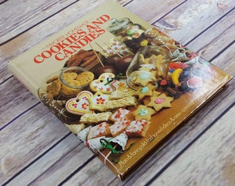 Könnte beinhalten: Ein Vintage-Kochbuch mit dem Titel "Favorite Homemade Cookies and Candies" mit einem bunten Bild von verschiedenen Keksen und Süßigkeiten auf dem Cover.