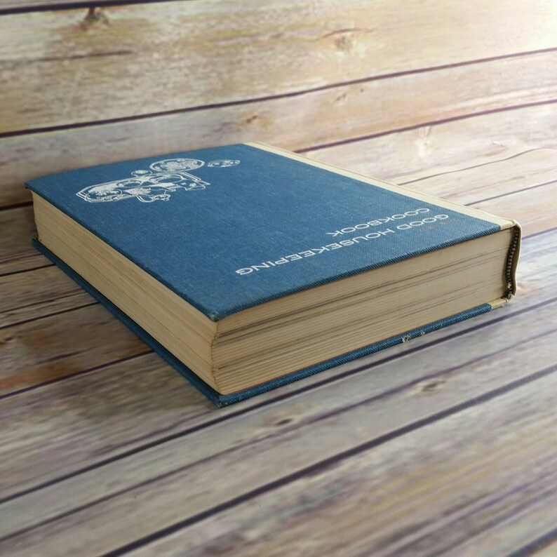 May include: A blue hardcover cookbook titled "Good Housekeeping Cookbook".