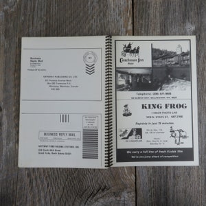 May include: A black and white photo of a motel called "Coachman Inn Motel" with a horse-drawn carriage in front. The motel is located at 120 Samish Way, Bellingham, WA 98225. The phone number is (206) 671-9000. Below the photo is an advertisement for King Frog 1 Hour Photo Lab, located at 1819 N. State St., Bellingham, WA. The ad states that reprints are available in just 15 minutes. The ad also includes a map showing the location of the photo lab.