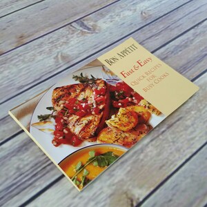 May include: A yellow cookbook with the title "Bon Appetit Fast & Easy Quick Recipes for Busy Cooks" and a photo of a plate of grilled fish with red salsa and roasted potatoes.