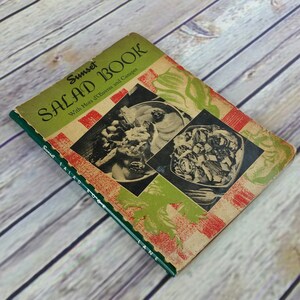 May include: Vintage cookbook titled "Sunset Salad Book" with Hors d'Oeuvres and Canapes. The cover features a green and red checkered pattern with images of salads.