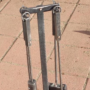 May include: A black metal fireplace tool set with a brush, poker, and shovel. The tools are hanging on a stand with a black metal base.