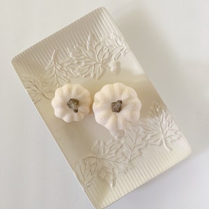 May include: White ceramic serving tray with an embossed leaf design. Two small white pumpkins are on the tray.