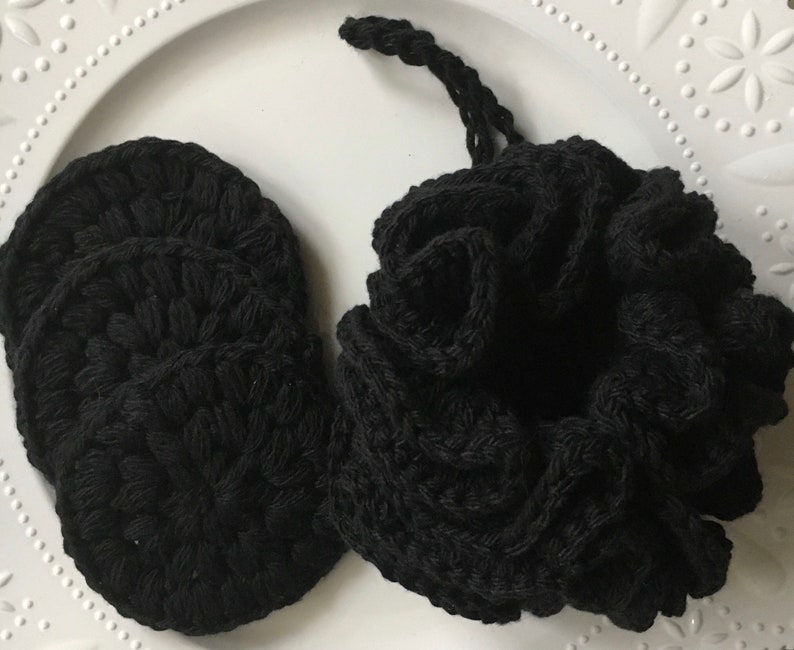 May include: A set of four black crocheted reusable makeup remover pads in a black crocheted drawstring bag.