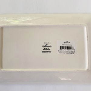May include: White rectangular ceramic serving tray with a raised rim. The tray has a Hallmark logo and the text "Dishwasher and Microwave Safe" printed on the bottom.