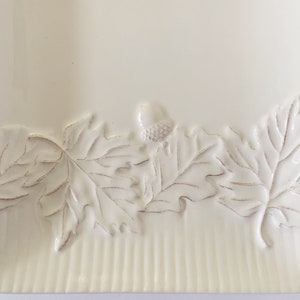 May include: White ceramic serving tray with a raised design of leaves and acorns around the edge.