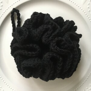 May include: Black crocheted hair scrunchie with a knotted design.