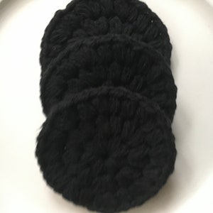 May include: Three black crocheted makeup remover pads stacked on top of each other.
