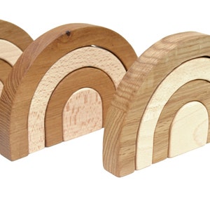 May include: Three wooden rainbow arches, each with three layers of different shades of brown and beige. The arches are stacked on top of each other, creating a cascading effect.