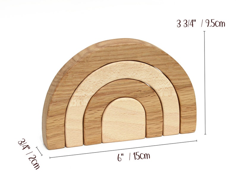 May include: Wooden rainbow stacking toy with four arches in different sizes. The largest arch is 3 3/4 inches tall and 6 inches wide. The toy is made of natural wood and has a light brown color.