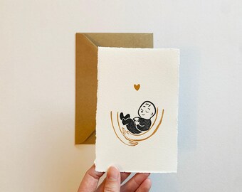 Illustrazione di nascita realizzata a mano come regalo. Biglietto di auguri per la nascita. Bambino in braccio. Neonato.