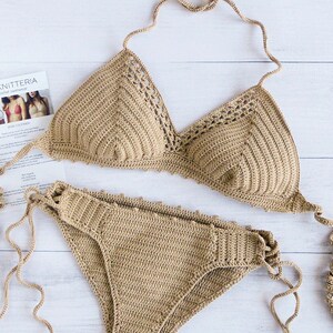 Peut inclure: Un ensemble de bikini crochet&eacute; de couleur beige clair. Le haut est de style triangle avec des bretelles r&eacute;glables et le bas est de style taille haute avec des liens sur les c&ocirc;t&eacute;s.