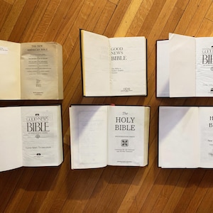 May include: A collection of six hardback books, all with the word "Bible" on the cover. The books are arranged in two rows of three, with the top row featuring "Good News Bible" and the bottom row featuring "The Holy Bible" and "Holy Bible".