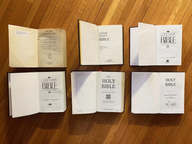 May include: A collection of six hardback books, all with the word "Bible" on the cover. The books are arranged in two rows of three, with the top row featuring "Good News Bible" and the bottom row featuring "The Holy Bible" and "Holy Bible".