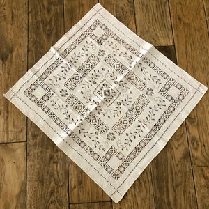 Peut inclure: Nappe en lin blanc avec un motif d&eacute;licat brod&eacute; en noir de formes g&eacute;om&eacute;triques et de motifs floraux.