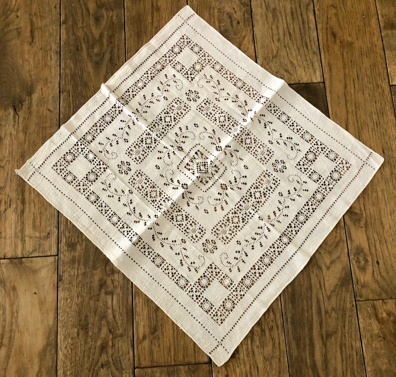 Peut inclure: Nappe en lin blanc avec un motif d&eacute;licat brod&eacute; en noir de formes g&eacute;om&eacute;triques et de motifs floraux.